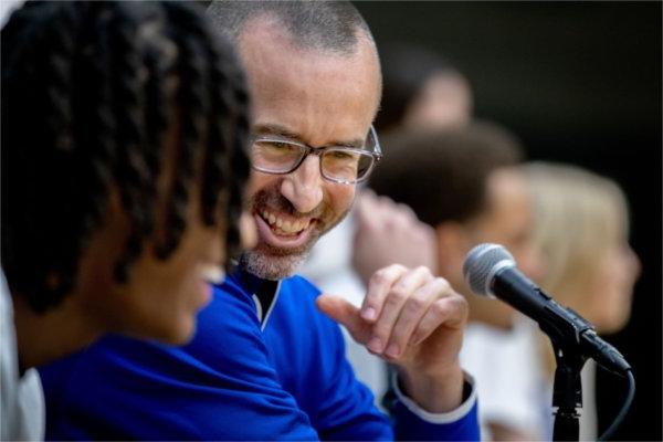 Jon Coles, assistant professor of sport management, laughs with Grand Valley student Quinn Wills. Wills was running the music portion of the game. 